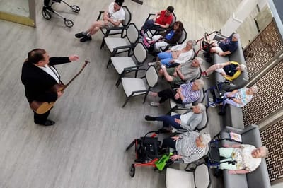 Residents enjoying a musical performance in a common area