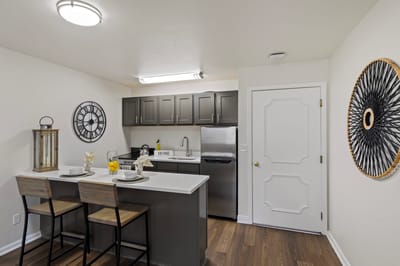 A modern kitchen area with seating.