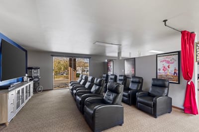 Comfortable common area with reclining chairs and a large screen
