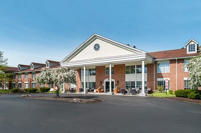 Exterior view of a senior living facility with landscaped entrance