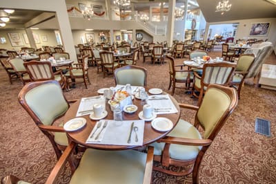 Dining area set for breakfast with tables and chairs