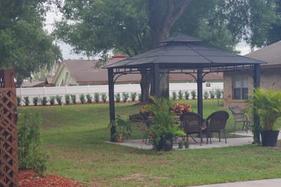 A gazebo set in a grassy area with seating