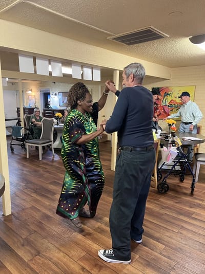 Residents dancing together in a social activity area