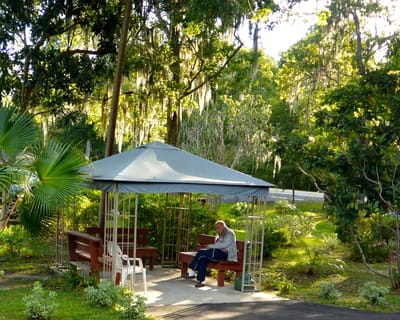 A resident sitting in a gazebo surrounded by nature