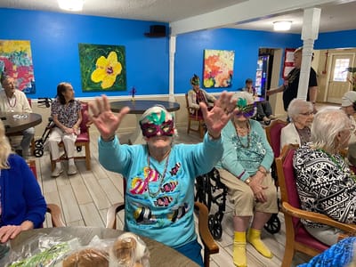 Residents celebrating with masks in an activity room