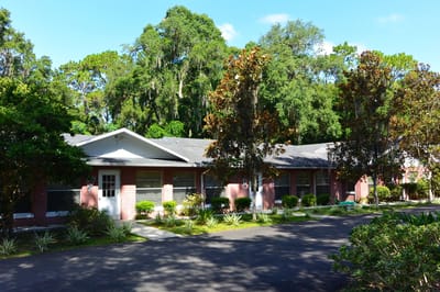 Exterior view of the assisted living residence surrounded by trees