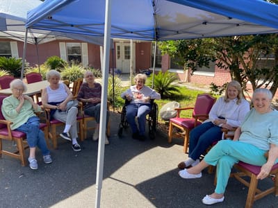 Residents enjoying time under a shaded area outdoors