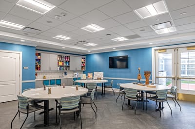 A bright common area with tables and art supplies