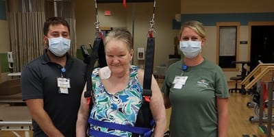 Staff assisting a resident with therapy equipment