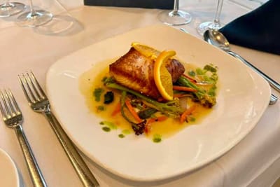 A beautifully plated fish dish with vegetables