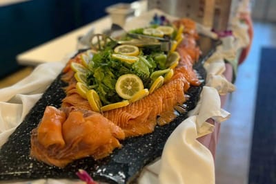 A beautifully arranged salmon platter with lettuce and lemon.