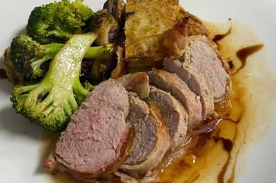 Plate of sliced meat with vegetables and sauce