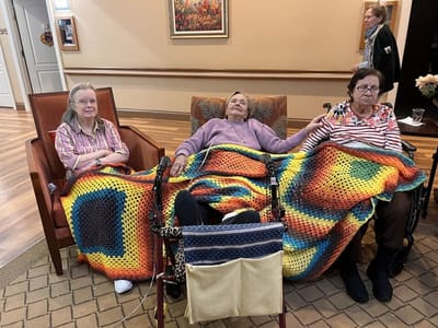 Three residents sitting together in a cozy common area