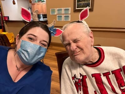 Staff and resident wearing festive headbands during an activity
