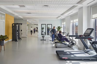 Residents exercising in a bright fitness room