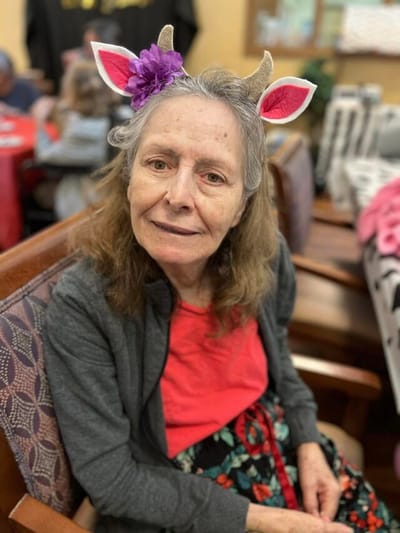 Resident in an activity room with fun headband