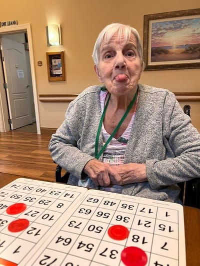 Resident joyfully playing bingo indoors