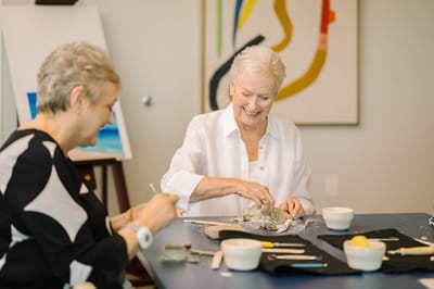 Residents engaging in an art activity at a table