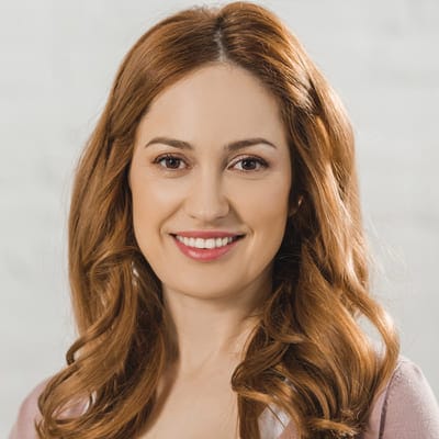 A smiling woman with long, wavy hair