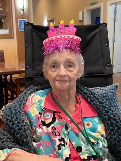 Resident celebrating with a birthday hat indoors