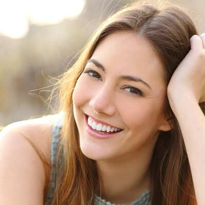 Smiling young woman with long hair outdoors