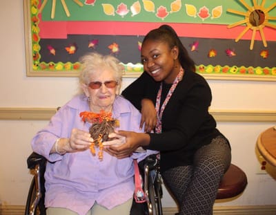 Resident and staff member celebrating with a craft