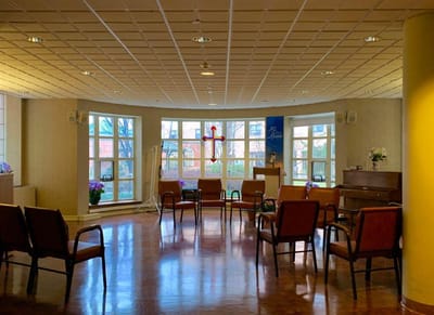 Bright common area with seating and a piano