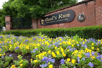 Exterior view of Paul's Run Retirement Community entrance with flowers