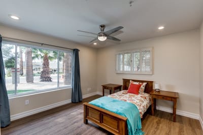 A cozy resident room with a bed and a view