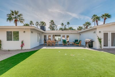Outdoor seating area with greenery and patio furniture