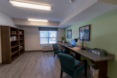 Interior view of a private resident room with desk and bookshelf