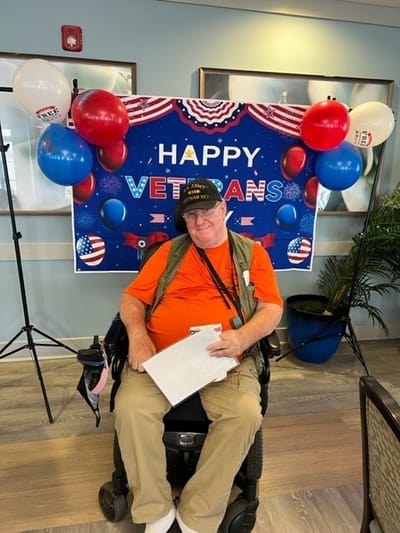 Resident celebrating Veterans Day in a decorated common area