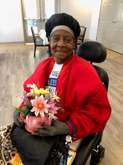 Resident holding a bouquet of flowers in the common area