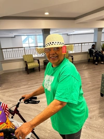 Resident in a common area wearing a green shirt and hat