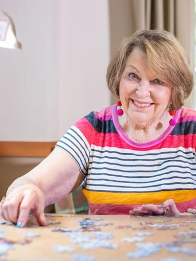 Senior woman enjoying a puzzle activity.