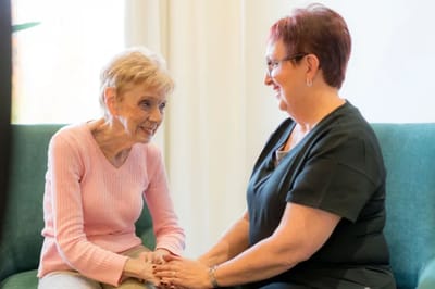Staff member interacting with a resident in a cozy setting