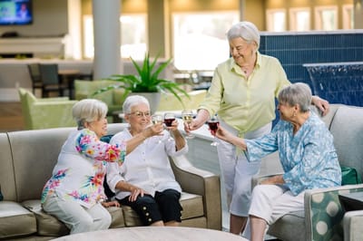 Residents toasting with drinks in a common area