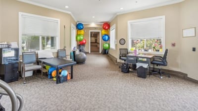 Common area with exercise equipment and colorful balloons.