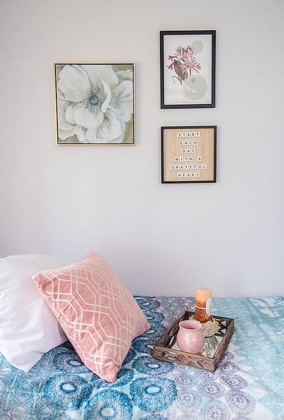 Cozy bedroom setup with decorative pillows and artwork.