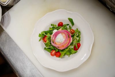 A plate of salad with cherry tomatoes and greens