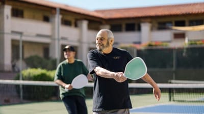 Residents enjoying a game of pickleball outdoors.