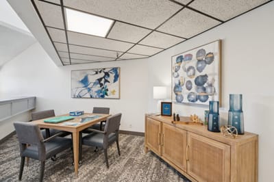 Well-decorated common area with a table and art