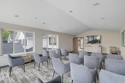Common area with gray chairs and a television.
