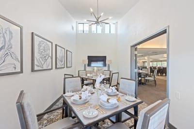 Elegant dining area with set tables and artwork.