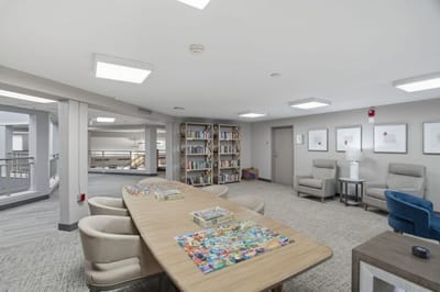 Common area with a large table and bookshelves.