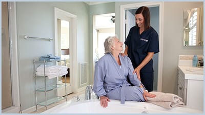 A caregiver assisting a resident in a bathroom