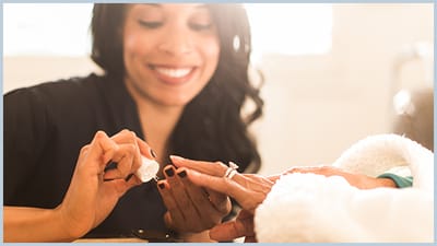 Staff member providing a manicure to a resident