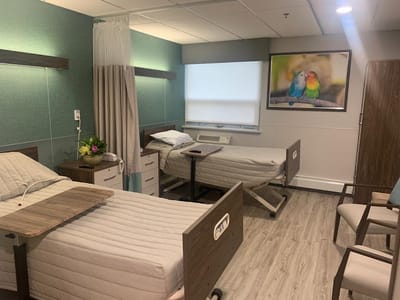 A well-furnished resident room with two beds and decor.