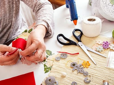 Close-up of hands sewing with craft supplies