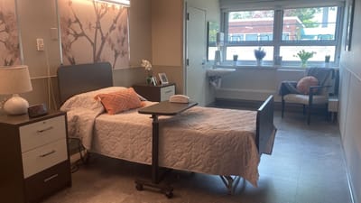 A cozy resident room with a bed and bedside table